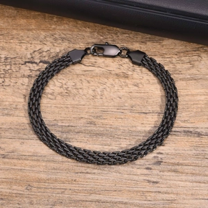 Macro detail of black stainless steel mesh bracelet with secure lobster clasp closure