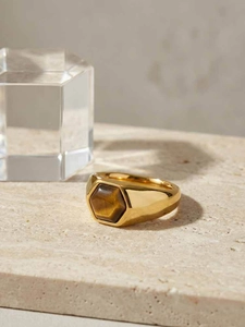 Gros plan sur bague en acier inoxydable doré avec pierre oeil de tigre hexagonale