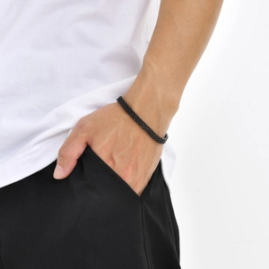 Detail of a black stainless steel mesh bracelet on wrist for a minimalist style