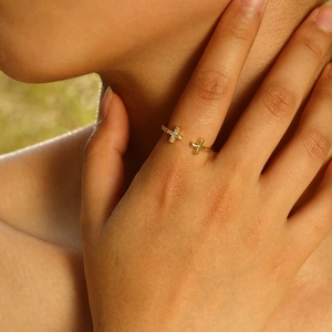 Close-up of adjustable gold cross ring with cubic zirconia stones on model hand
