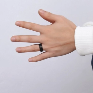 Men wearing 8mm matte black tungsten steel ring with rose gold accent on hand