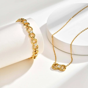 Détail macro du collier doré en acier inoxydable avec anneaux entrelacés et zircons