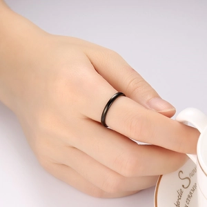 Minimalist black polished ring on finger with elegant mirror finish and sleek design