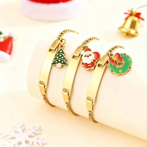 Detailed view of gold ID bracelets with Christmas charms on a festive display stand