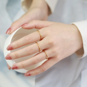Detail of 1mm gold stackable rings with zircon stones shown on fingers
