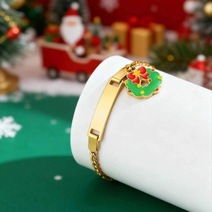 Close-up of golden stainless steel bracelet with a blank ID plate and Christmas wreath charm