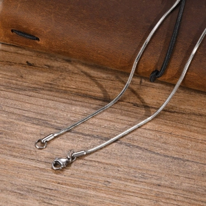 Macro shot of silver stainless steel snake chain necklace with lobster clasp closure