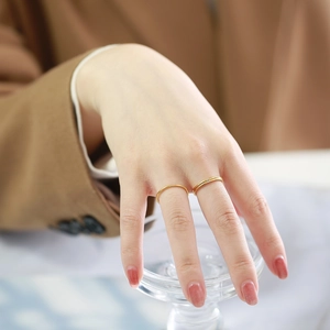 Detail of 1mm gold-plated stainless steel rings stacked on fingers for a layered look