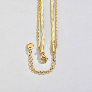 Detail of layered gold stainless steel necklace with flat snake chain and lobster clasp