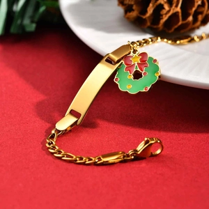 Detail of gold stainless steel ID bracelet with Christmas wreath charm and curved plate