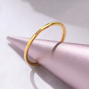 Macro detail of 1mm gold stackable ring featuring three flush-set cubic zirconia stones