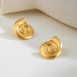 Close-up of 18K gold spiral nautilus stud earrings with matte brushed metal texture