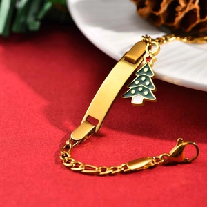Detail of gold stainless steel bar bracelet with a green Christmas tree charm on red background