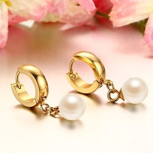 Elegant 8mm pearl drop earrings with golden hoops on a reflective mirror background