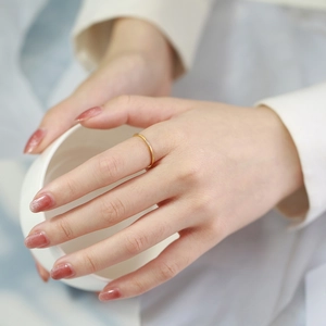 Detail of 1mm gold minimalist stainless steel ring with three cubic zirconia stones