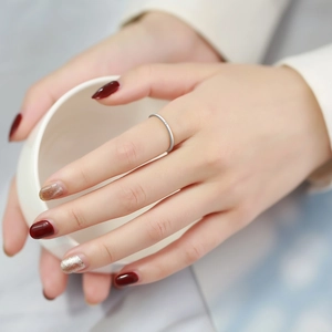 Close-up of minimalist silver stainless steel ring with micro cubic zirconia on female hand