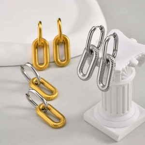 Detail view of oval drop earrings with fine textured finish in gold and silver