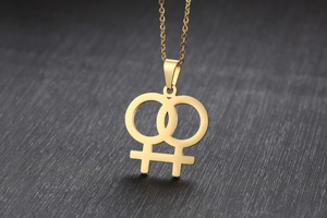 Nahaufnahme der polierten goldfarbenen Edelstahl-Halskette mit Doppel-Venus-Symbol-Anhänger