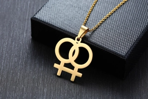 Makroaufnahme der goldenen Edelstahlkette mit ineinandergreifenden weiblichen Symbolen