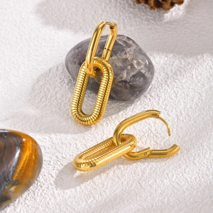 Detailed macro view of gold-plated oval chain earrings with textured ribbed finish