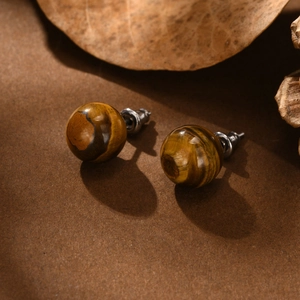 Macro shot of tiger eye stud earrings with natural silk luster and stainless steel pins