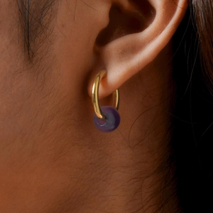 Macro shot of 18K gold-plated titanium steel hoop earring with a purple amethyst bead