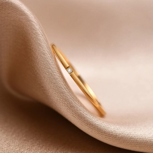 Macro shot of a 1mm gold stainless steel stackable ring with a tiny cubic zirconia stone