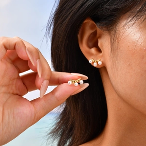 Detail shot of vintage 18k gold plated curved studs with three small white pearls