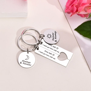 Close-up of stainless steel couple keychains with sun moon motifs and romantic engravings