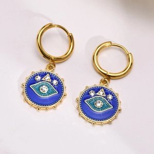 Detailed macro view of gold evil eye drop earrings with blue enamel and white crystals