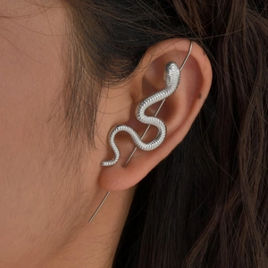 Vue macro détaillée d'un tour d'oreille serpent argenté porté sur l'oreille du mannequin
