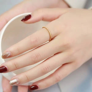 Minimalist 1mm gold stainless steel ring with micro zircon stone on female hand