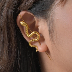 Gros plan d'un ear cuff serpent doré révélant des textures d'écailles détaillées