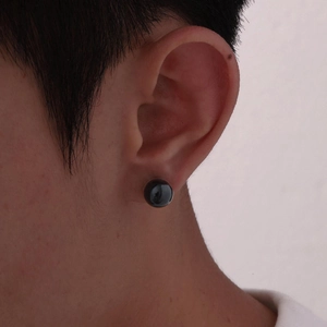 Polished black round tiger eye stone stud earrings with stainless steel posts on ear