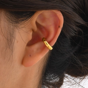 Detail eines 18K vergoldeten C-förmigen Ear Cuff mit poliertem Finish am Ohr getragen