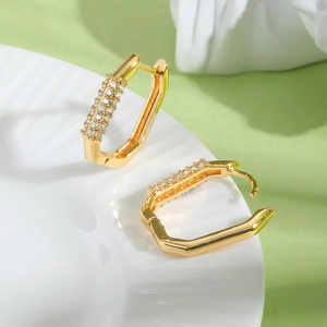 Detailed macro view of gold-plated geometric hoop earrings with triple row zircon inlay