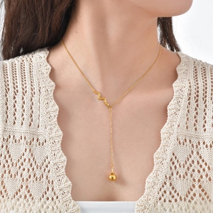 Detail der 18K vergoldeten Y-Halskette mit Schlangenkette und glänzendem Wassertropfen