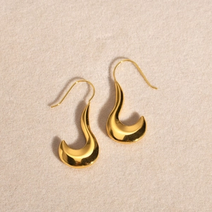 Detailed view of polished golden U-shaped earrings with sleek hammered water ripple texture