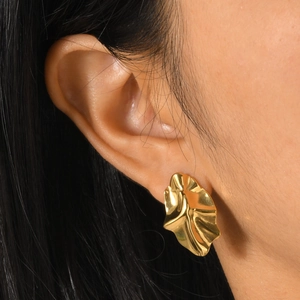 Close-up of a model wearing minimalist golden irregular wrinkled geometric stud earrings