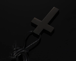 Makroaufnahme der mattschwarzen Inverted-Cross-Halskette aus Edelstahl mit Textilkordel