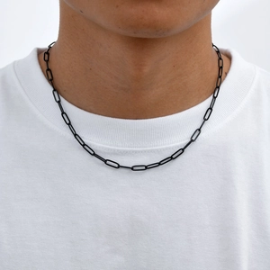 Dettaglio della collana a catena nera opaca su t-shirt bianca, stile urbano minimale