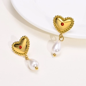 Detail of gold heart earrings with red crystal stone and white teardrop pearl pendant