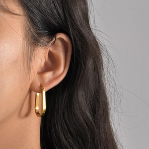 Minimalist gold U-shaped stainless steel earrings on female model for daily wear