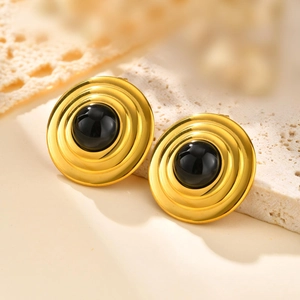 Orecchini a disco dorati vintage con onice nero su sfondo di pietra e pizzo elegante