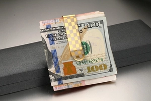 Macro shot of 53mm gold and silver checkered stainless steel money clip with US bills
