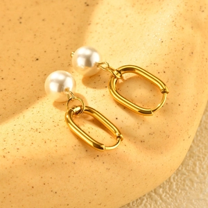 Détail de boucles d'oreilles vintage françaises ovales dorées avec perles élégantes