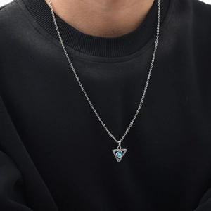 Celtic knot triangle pendant with blue moonstone on a black neck sweater