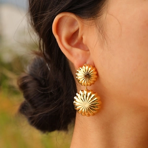Détail de boucles d'oreilles pampilles plaquées or 18K avec texture soleil rayonnant