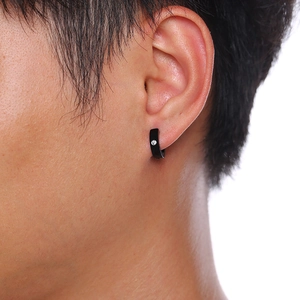 Gros plan d'une boucle d'oreille créole noire en acier inoxydable avec petit zircon