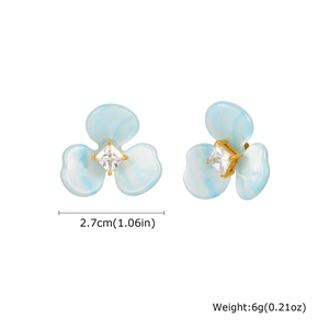Détail de la taille et du poids des boucles fleurs en résine bleue avec zircon carré
